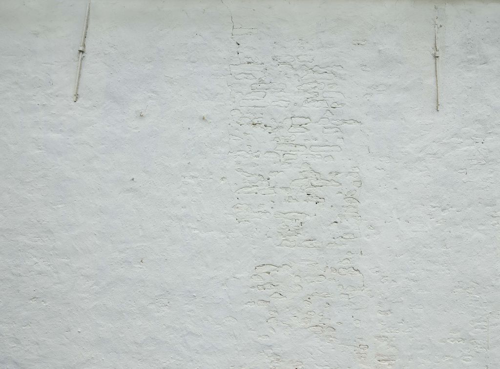 Muur met wit stucwerk en muurankers