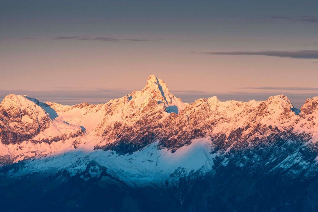 Avondlicht over besneeuwde bergtoppen