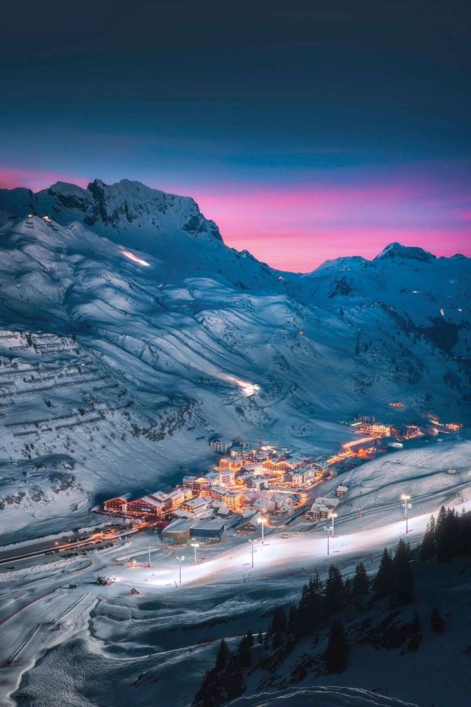 Sneeuwdorp onder paarse avondlucht