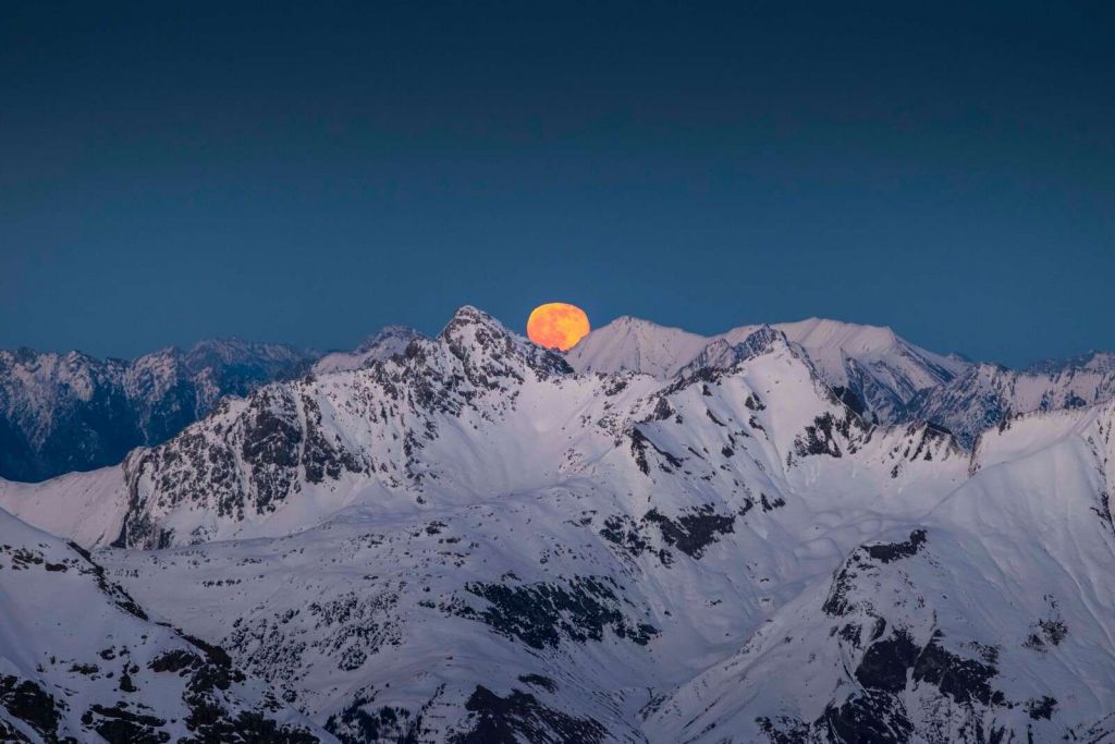 Volle maan boven alpentoppen