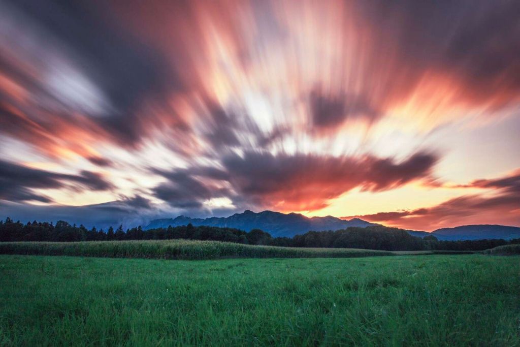 Zonsondergang boven groene vlakte