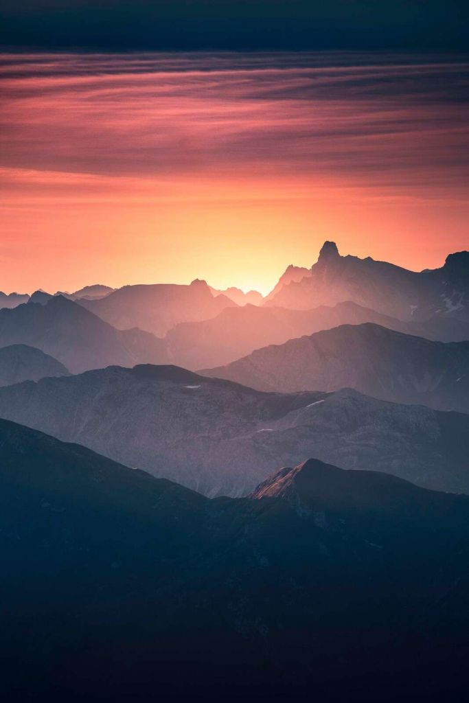 Zonsopkomst over paarse bergflanken