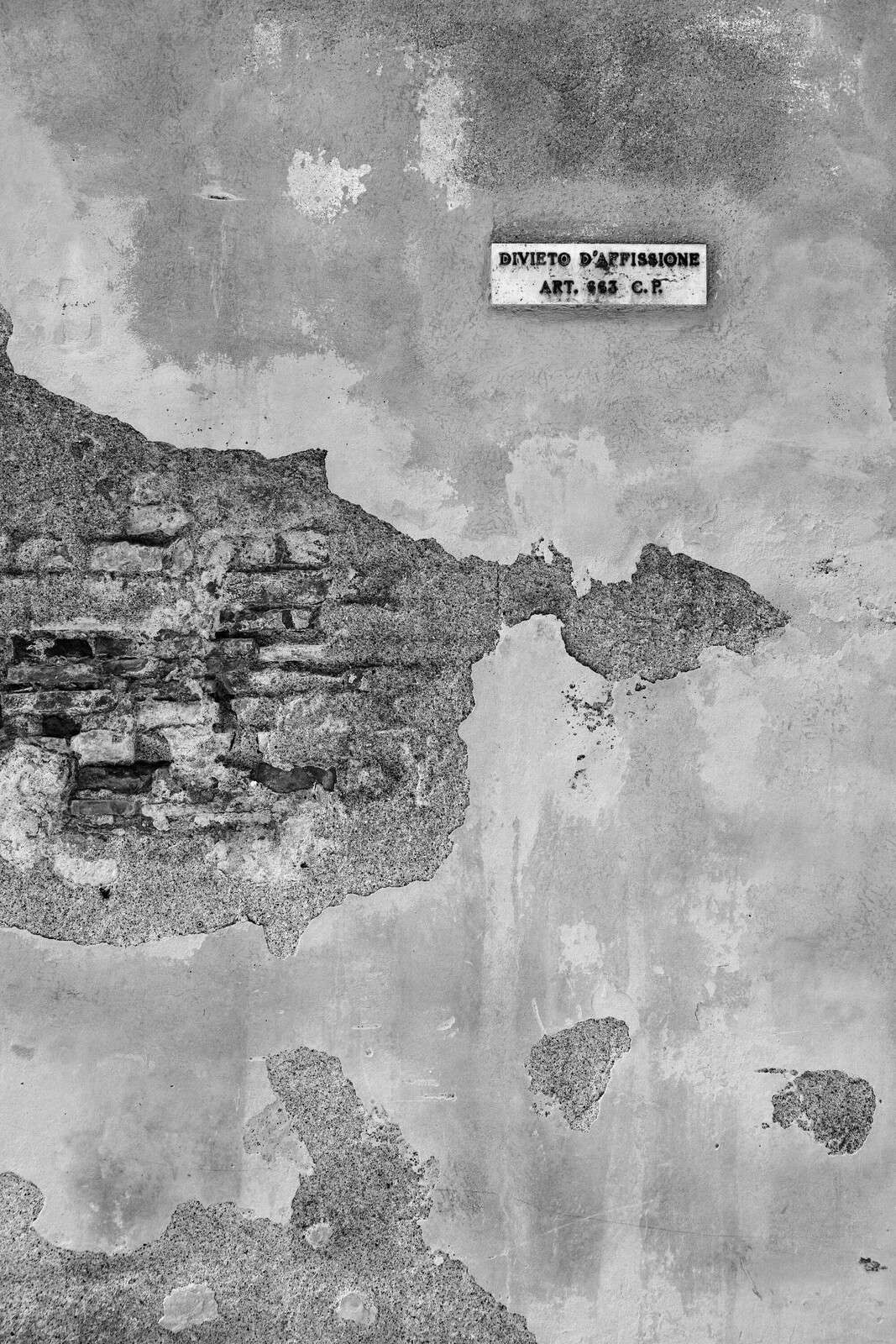 Verweerde muur met Italiaanse tekst