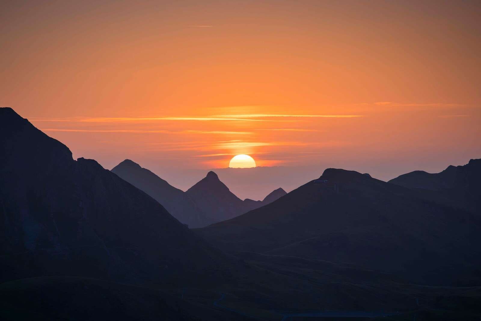 Zonsondergang tussen bergtoppen